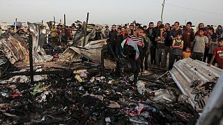 Palestinians look at the destruction after an Israeli strike where displaced people were staying in Rafah, Gaza Strip, Monday, May 27, 2024