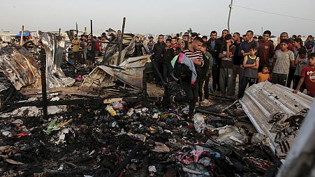Palestinians look at the destruction after an Israeli strike where displaced people were staying in Rafah, Gaza Strip, Monday, May 27, 2024. 