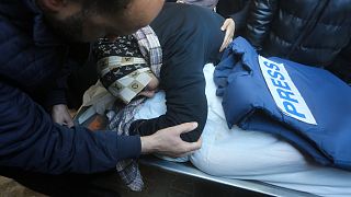 سيدة تحتضن جثمان الصحفي الفلسطيني أكرم الشافعي، الذي قُتل في القصف الإسرائيلي لقطاع غزة، في مشرحة مستشفى غزة الأوروبي في رفح، السبت، 6 يناير