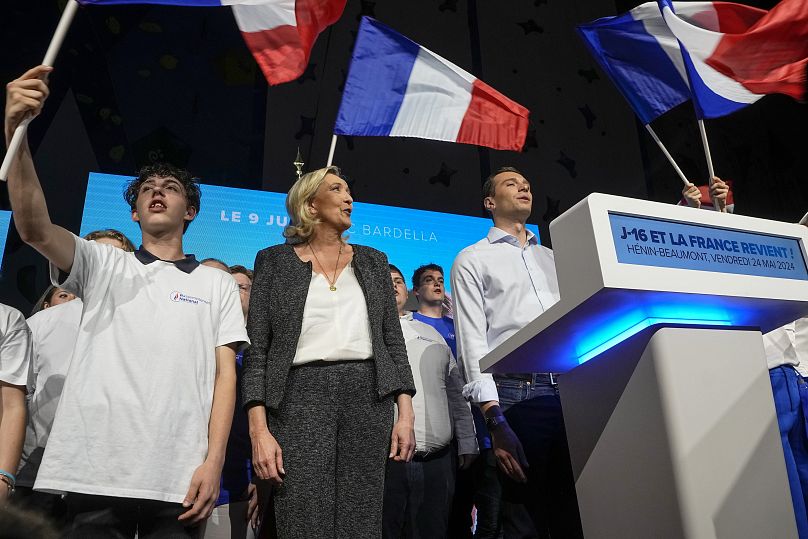 رهبر حزب راست افراطی فرانسه مارین لوپن (چپ)، و نامزد اصلی حزب برای انتخابات آتی اروپا، جردن باردلا،‌ پشت تریبون)، ۲۴ مه ۲۰۲۴