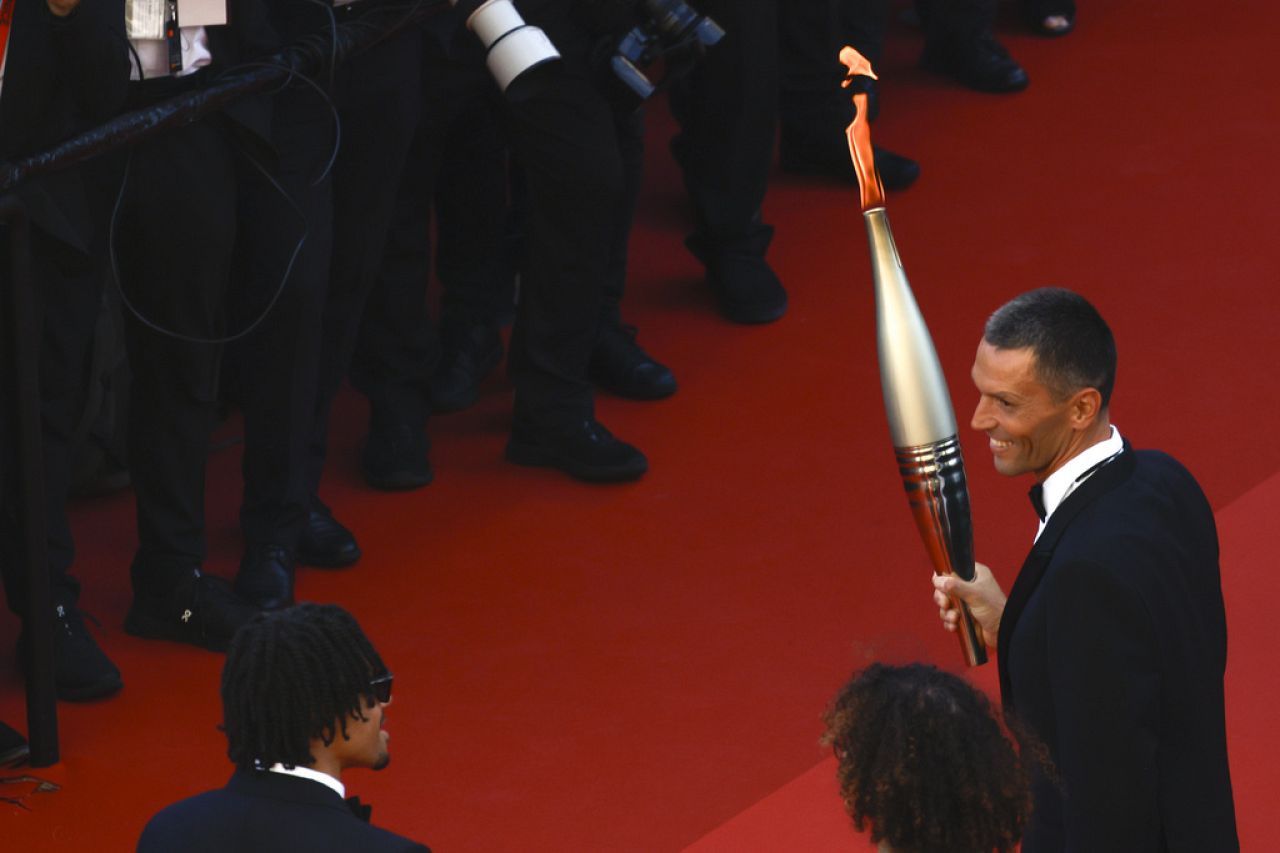 Alexis Hanquinquant poses with the Olympic flame at the 'Marcello Mio' premiere during the 77th Cannes Film Festival in southern France on 21 May 2024.