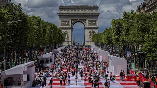 يتناول الناس غداءهم كجزء من نزهة عملاقة في شارع الشانزليزيه، أمام قوس النصر، تنظمها لجنة الشانزليزيه، الأحد 26 مايو 2024 في باريس.
