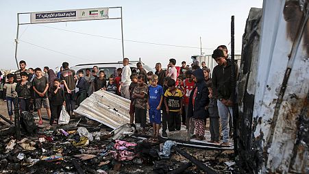 Des Palestiniens observent les dégâts causés par une frappe israélienne sur un lieu où se trouvaient des personnes déplacées à Rafah (bande de Gaza), le lundi 27 mai 2024