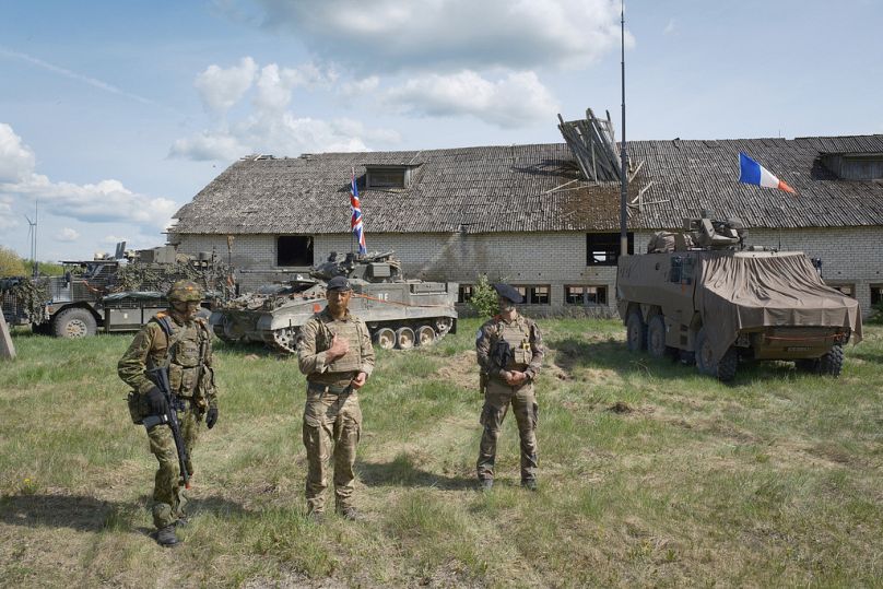 A partir da esquerda, militares da Estónia, do Reino Unido e da França participam no exercício Spring Storm da NATO em Kilingi-Nomme, Estónia, quarta-feira, 15 de maio de 2024