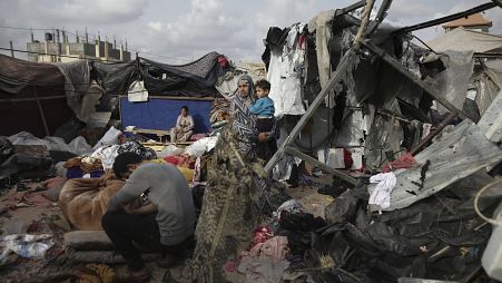 ازحون فلسطينيون يتفقدون خيامهم التي دمرها القصف الإسرائيلي، بجوار منشأة تابعة للأونروا غرب مدينة رفح، قطاع غزة، الثلاثاء، 28 مايو، 