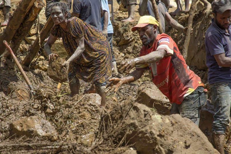 Dorfbewohner suchen nach dem Erdrutsch im Dorf Yambali in Papua-Neuguinea nach Überresten ihrer Angehörigen, Montag, 27. Mai 2024.