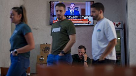 Kunden stehen in einem Restaurant, während der spanische Premierminister Pedro Sanchez in einer Fernsehsendung in Spanien, am Dienstag, 28. Mai 2024, auftritt.