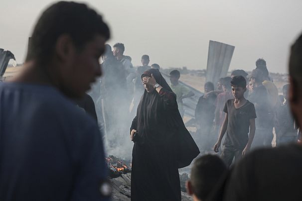 Des Palestiniens observent les dégâts causés par une frappe israélienne sur un lieu où se trouvaient des personnes déplacées à Rafah, dans la bande de Gaza, le 27 mai 2024.