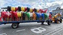 A tractor pulls a trailer filled with plastic cows prior to a protest of farmers outside of a meeting of EU agriculture ministers in Brussels.