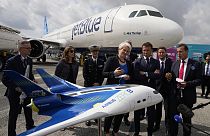 El presidente francés, Emmanuel Macron, en el centro a la derecha, y el consejero delegado de Airbus, Guillaume Faury, observan un concepto de avión híbrido de hidrógeno, en el Salón Aeronáutico de París del año pasado.