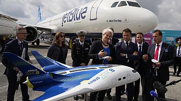 French President Emmanuel Macron, center right, and Airbus CEO Guillaume Faury, look at a concept hybrid-hydrogen aircraft, at the Paris Air Show last year