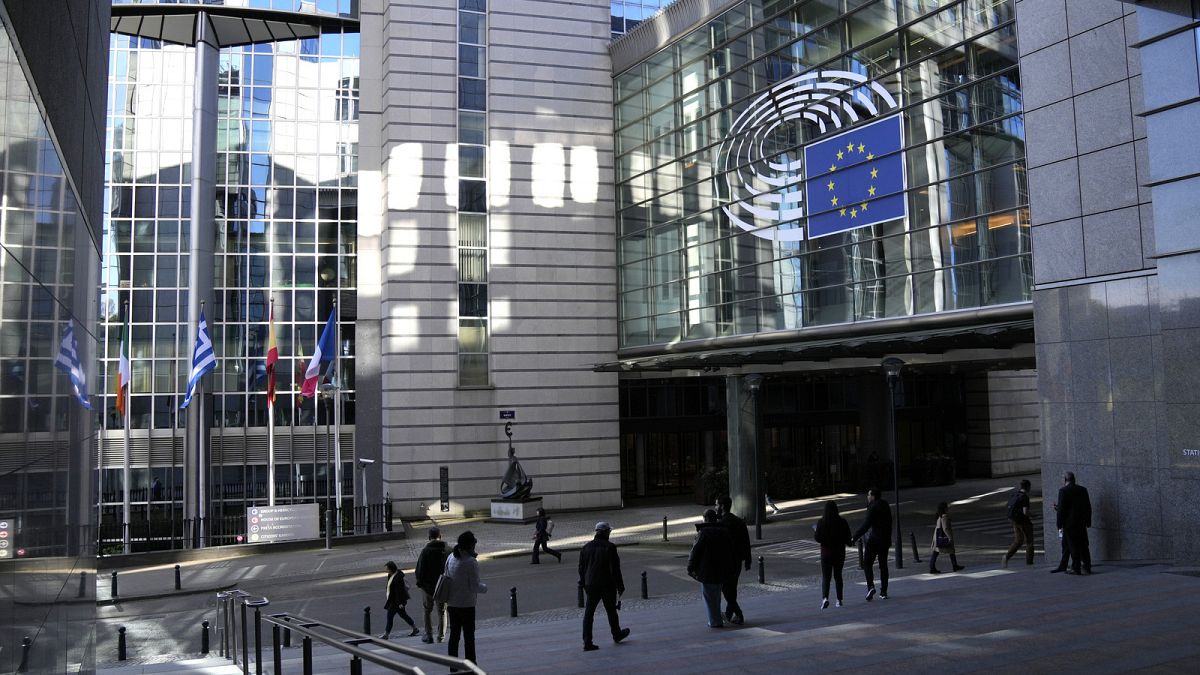 Menschen spazieren vor dem Europäischen Parlament in Brüssel