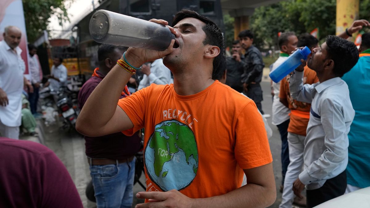 A man drinks water at a roadside stall serving free drinking water to commuters as heat wave continues to grip the Indian capital, New Delhi.