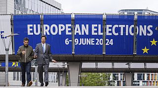 Des personnes marchent devant le Parlement européen avant un débat avec les principaux candidats aux élections du Parlement européen à Bruxelles, le jeudi 23 mai 2024.