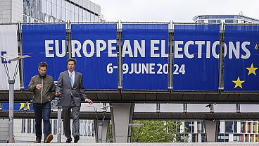 Menschen gehen vor dem Europäischen Parlament vor einer Debatte mit den Spitzenkandidaten für die Wahlen zum Europäischen Parlament in Brüssel, Donnerstag, 23. Mai 2024.