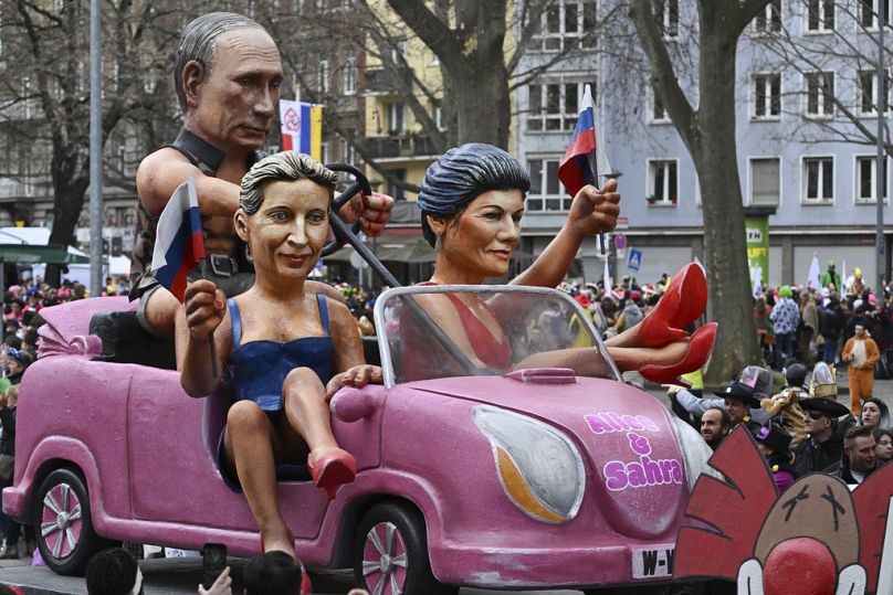 Политическая сатира на карнавале в Майнце. Алиса Вайдель (в центре) и Сара Вагенкнехт в автомобиле, которым управляет президент РФ Владимир Путин. Февраль 2024 года