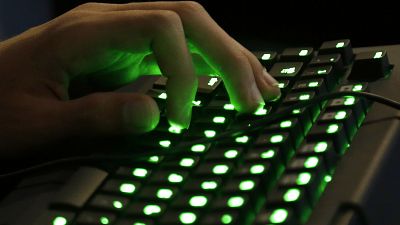 La main d'une personne repose sur un clavier éclairé.