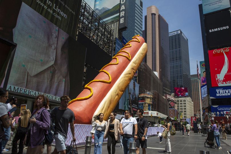 A 65-foot- long sculpture titled Hot Dog in the City by artists Jen Catron and Paul Outlaw is in Times Square in New York, May 2024