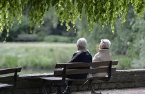 Um casal de idosos senta-se num banco de um parque em Gelsenkirchen, na Alemanha.