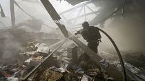 Firefighters put out a fire after a Russian missile hit a large printing house in Kharkiv, May 23, 2024