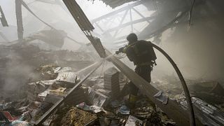 Firefighters put out a fire after a Russian missile hit a large printing house in Kharkiv, May 23, 2024