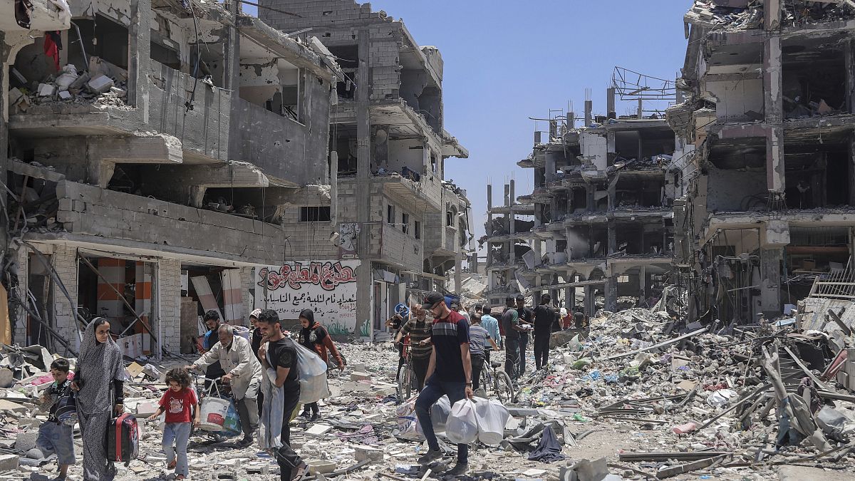 Palestinos caminan entre la destrucción tras una ofensiva aérea y terrestre israelí en Jabaliya, 30 de mayo de 2024.