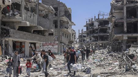 Palestinesi camminano tra le macerie dopo l'offensiva aerea e terrestre israeliana a Jabaliya che ha distrutto un'area dove vivevano circa 100 mila persone (30 maggio 2024)