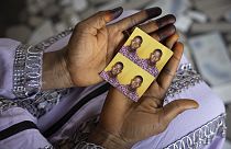 Mariama Sylla, sister of Ousmane Sylla, holds photos of him in their house at Matoto Bonagui, a suburb of Conakry, Guinea, Monday, April 8, 2024.