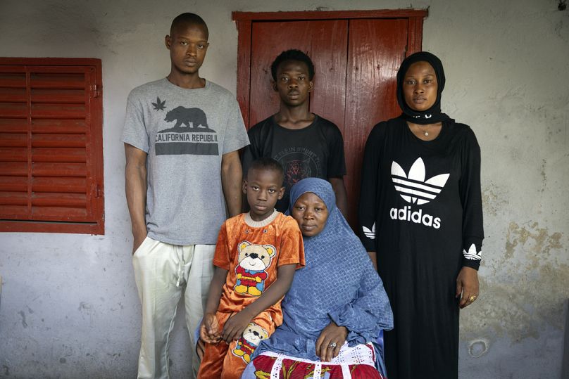 The mother and siblings of the late Ousmane Sylla gather for a photograph at their house after his funeral in Matoto Bonagui, a suburb in Conakry, Guinea, Tuesday, April 9, 20