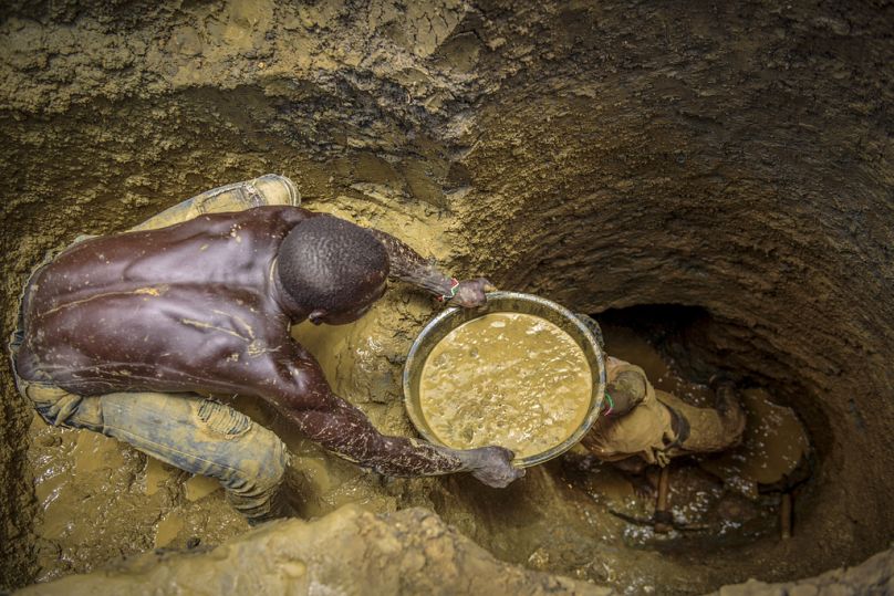 FILE- Miners extract mud they hope contains gold at a gold mining site at which adults and 