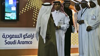 Employees of the Saudi Aramco oil company prepare for the first day of the Arab Oil and Gas exhibition in Dubai