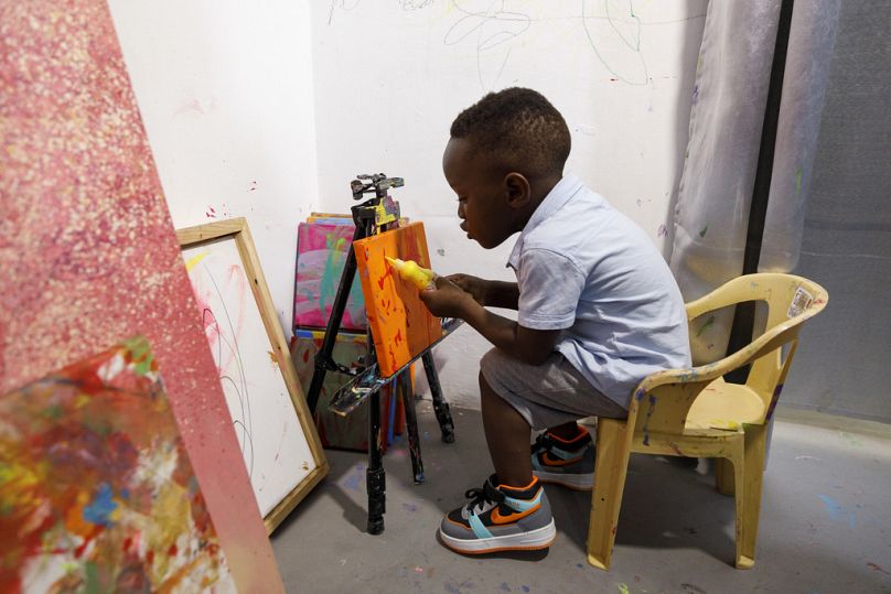 Ace-Liam Nana Sam Ankrah, who will turn two in July, paints at his mother's art gallery in Accra, Ghana, Monday, May 27, 2024.