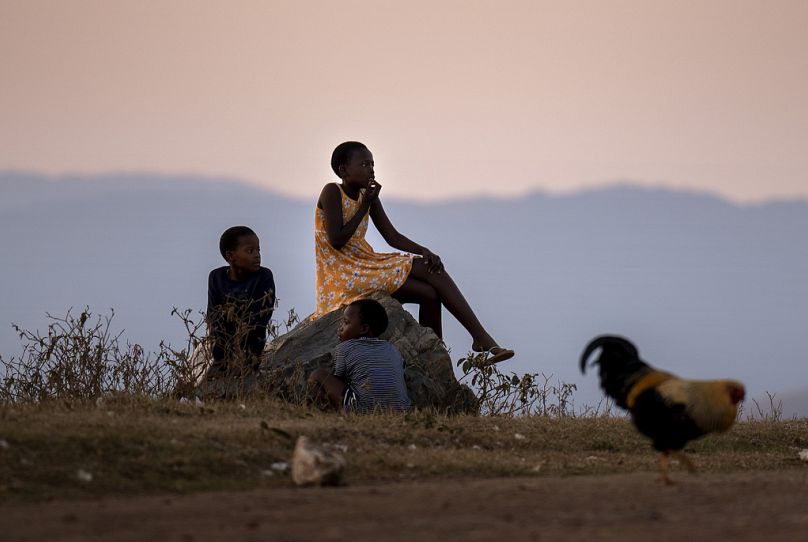 Children sit by the side of the road next to a polling station, during general elections in Nkandla, Kwazulu Natal, South Africa, Wednesday May 29, 2024.