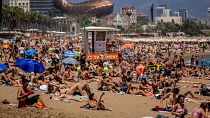 Des personnes prennent un bain de soleil sur la plage de Barcelone, en Espagne.