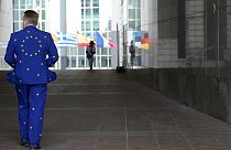 A man wears a suit in the EU colors as he walks outside the European Parliament