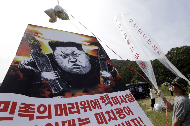 Los desertores norcoreanos se preparan para lanzar globos con folletos y una pancarta denunciando al líder norcoreano Kim Jong-un.