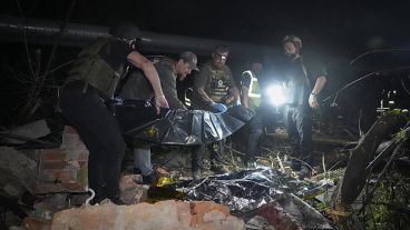 Police officers cover a dead body after the Russian missile attack hit an apartment building in Kharkiv, May, 31, 2024