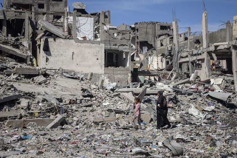Eine Palästinensierin und ein palästinensisches Mädchen gehen durch die Trümmer zerstörter Häuser nach einem israelischen Luftangriff in Dschabaliya,, 31. Mai 2024