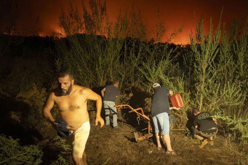Local residents try to clean a forest to prevent it from flames as fire advances in La Orotava in Tenerife, Canary Islands, Spain in August 2023