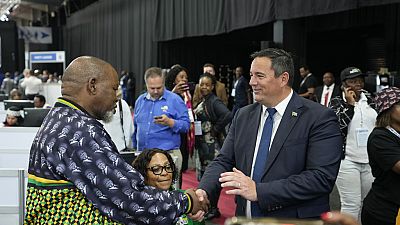 Leader of the main opposition Democratic Alliance John Steenhuisen, right, shakes hands with ANC's Chairman. Gwede Mantashe, left