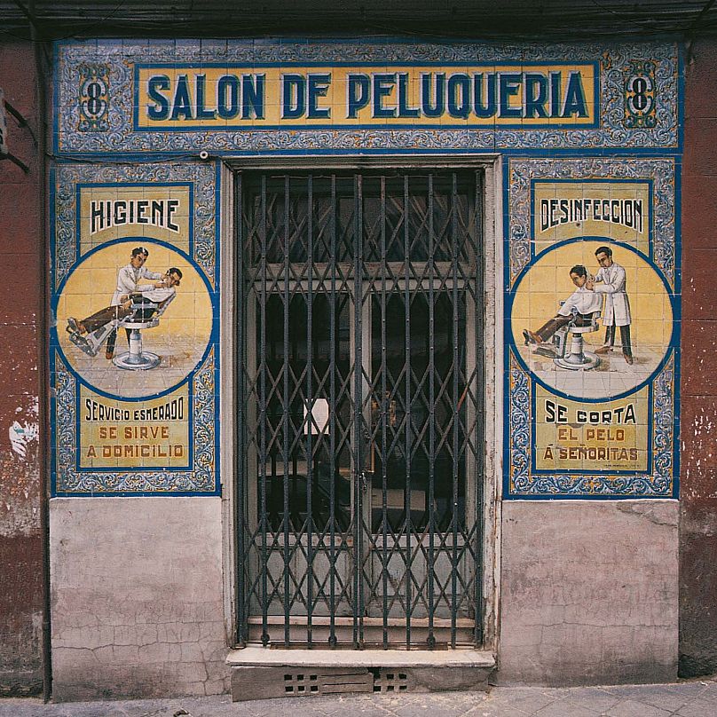 “We cut the hair of gentlemen” reads one part of the sign, while another says “We do haircuts at home”.