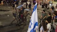Израильская полиция удаляет человека, протестующего против правительства премьер-министра Биньямина Нетаньяху, на митинге в Тель-Авиве, 1 июня 2024 года.