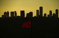 The sun sets behind high buildings of a financial business area in Istanbul, Turkey, Friday, March 22, 2024. 