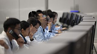 Pessoal técnico trabalha no Centro de Controlo Aeroespacial de Pequim (BACC), em Pequim, no domingo, enquanto a nave aterra na Lua