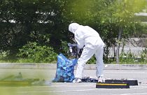 An officer wearing protective gear collects the trash from a balloon presumably sent by North Korea, in Siheung, South Korea, 2 June 2024