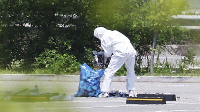 An officer wearing protective gear collects the trash from a balloon presumably sent by North Korea, in Siheung, South Korea, 2 June 2024