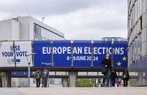 People walk outside the European Parliament prior to a debate with the lead candidates for the European Parliament elections in Brussels, Thursday, May 23, 2024. 