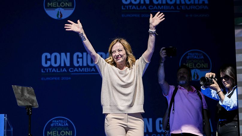 Italian Premier Giorgia Meloni waves from the stage during an electoral rally ahead of the EU parliamentary elections in Rome