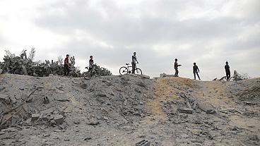 Palestinianos observam a destruição após um ataque aéreo israelita em Khan Younis, na Faixa de Gaza, segunda-feira, 3 de junho de 2024.