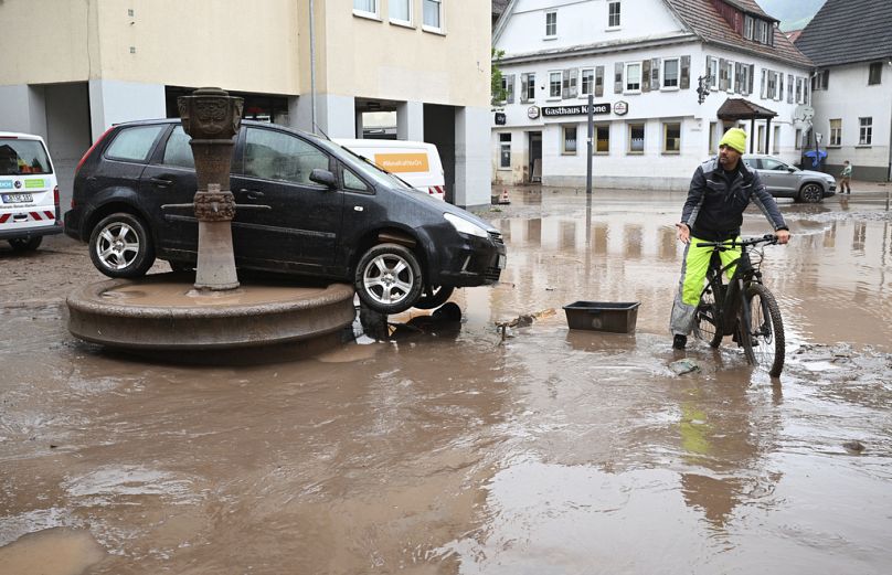A car washed away by floodwater rests on a well, in Rudersberg, Germany, Monday, June 3, 2024. 
